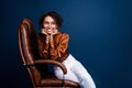 Photo portrait of lovely young lady office furniture sit comfy wear trendy brown satin formalwear isolated on dark blue Royalty Free Stock Photo