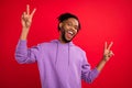 Photo portrait man with dreadlocks showing v-sign laughing overjoyed isolated vibrant red color background Royalty Free Stock Photo