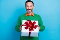 Photo portrait of mature handsome man holding big giftbox celebrate red bow wear trendy green garment isolated on blue Royalty Free Stock Photo