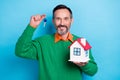 Photo portrait of mature handsome man holding small house key professional realtor wear trendy green look isolated on Royalty Free Stock Photo