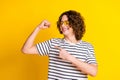 Photo portrait of nice teenager man point biceps look muscle dressed stylish striped clothes isolated on yellow color Royalty Free Stock Photo