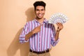 Photo portrait of nice young guy hold point money cash fan wear trendy striped formalwear garment isolated on beige Royalty Free Stock Photo