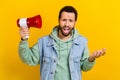 Photo portrait of nice young man hold loudspeaker scream dissatisfied dressed stylish khaki clothes isolated on yellow Royalty Free Stock Photo