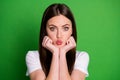 Photo portrait of pouting girl holding face head with two hands isolated on vivid green colored background Royalty Free Stock Photo