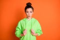 Photo portrait of pouting girl pulling hoodie strings isolated on vivid orange colored background