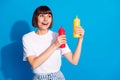 Photo portrait pretty girl smiling keeping ketchup mustard looking copyspace isolated vibrant blue color background Royalty Free Stock Photo