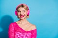 Photo portrait of pretty young girl headphones look empty space dressed stylish pink knitted outfit  on blue Royalty Free Stock Photo