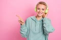 Photo portrait of pretty young girl headphones point empty space toothy smile dressed stylish khaki look isolated on Royalty Free Stock Photo