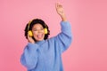 Photo portrait of pretty young girl listen music headphones sing dressed stylish blue knitwear outfit isolated on pink Royalty Free Stock Photo