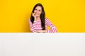 Photo portrait of pretty young woman behind white wall advertise blank card wear trendy striped clothes isolated on Royalty Free Stock Photo
