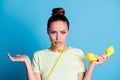 Photo portrait of sad grumpy girl showing misunderstanding keeping yellow retro phone with wire around neck isolated on Royalty Free Stock Photo