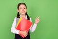 Photo portrait schoolgirl keeping book in school showing finger copyspace isolated pastel green color background