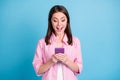 Photo portrait of screaming shocked girl holding phone in two hands isolated on pastel blue colored background