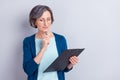 Photo portrait of senior business woman concentrated keeping clipboard pen reading isolated on grey color background