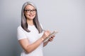 Photo portrait of senior businesswoman writing notes in planner wearing glasses interview isolated on grey color Royalty Free Stock Photo