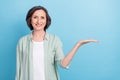 Photo portrait senior woman keeping blank space on hand smiling isolated pastel blue color background Royalty Free Stock Photo