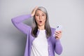 Photo portrait of shocked lady holding phone seeing crazy discounts wearing violet cardigan isolated on grey colored