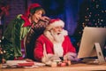 Photo portrait of shocked santa claus and elf browsing internet on pc Royalty Free Stock Photo