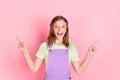 Photo portrait of small girl amazed pointing fingers up copyspaces isolated on pastel pink color background