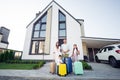 Photo portrait of smiling big full family with small kids outside house with luggage near car keeping bags ready to go Royalty Free Stock Photo