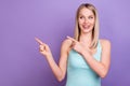 Photo portrait smiling blonde woman curious pointing finger copyspace isolated pastel violet color background