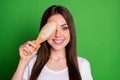 Photo portrait of smiling girl covering one eye with hairbrush isolated on vivid green colored background