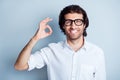 Photo portrait of smiling guy showing okay sign isolated on clear white colored background Royalty Free Stock Photo