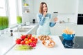 Photo portrait smiling woman in apron thoughtful cooking spaghetti reading recipe on tablet