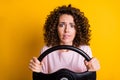 Photo portrait of stressed nervous female driver keeping steering wheel biting lip isolated on vibrant yellow color