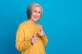 Photo portrait of stunning grandma fingers point you cool energetic promoter wear trendy yellow outfit isolated on blue