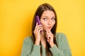 Photo portrait of thoughtful girl looking at blank space talking on phone isolated on vivid yellow colored background Royalty Free Stock Photo