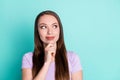 Photo portrait of thoughtful girl smiling looking at blank space touching face isolated on vivid teal color background Royalty Free Stock Photo