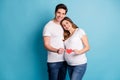 Photo portrait of two people couple husband pregnant wife hugging holding red heart card isolated bright blue color Royalty Free Stock Photo