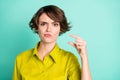 Photo portrait of unhappy girl showing small size fingers isolated on bright turquoise color background Royalty Free Stock Photo