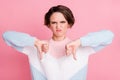 Photo portrait of upset woman showing two thumbs down isolated on pastel pink colored background Royalty Free Stock Photo