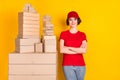 Photo portrait of woman crossed hands smiling near boxes stack shipment service isolated bright yellow color background