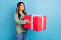 Photo portrait woman giving big present box in stylish outfit on holiday isolated pastel blue color background Royalty Free Stock Photo