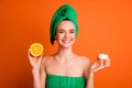 Photo portrait of woman holding citrus slice cream jar in hands isolated on bright orange colored background