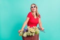 Photo portrait woman keeping retro bicycle basket wild flowers wearing sunglass isolated vivid teal color background