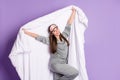 Photo portrait of woman keeping white blanket smiling wearing pajama sleeping mask isolated pastel violet color