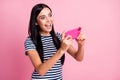 Photo portrait of woman playing video games holding phone in two hands vertically isolated on pastel pink colored Royalty Free Stock Photo