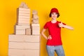 Photo portrait of woman showing thumb-up sign near big pile of boxes shipment service isolated vibrant yellow color