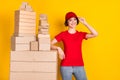 Photo portrait of woman smiling near boxes stack shipment service isolated vibrant yellow color background