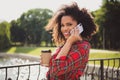 Photo portrait woman walking in city near lake drinking coffee talking on cellphone smiling Royalty Free Stock Photo