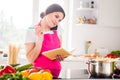 Photo portrait woman writing recipe in blocknote cooking pasta talking on smartphone Royalty Free Stock Photo