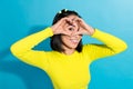 Photo portrait of young charming pretty korean girlfriend showing fingers love symbol eye window spying isolated on blue Royalty Free Stock Photo