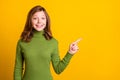 Photo portrait young girl pointing fingers blank space recommend advise bright green color background