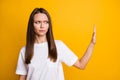 Photo portrait of young irritated girl demonstrating prohibition sign with hand looking at copyspace vivid