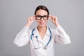 Photo portrait young nurse with sthethoscope smiling wearing spectacles  grey color background Royalty Free Stock Photo