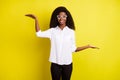 Photo portrait of young woman comparing copyspaces keeping on hands smiling isolated vibrant yellow color background